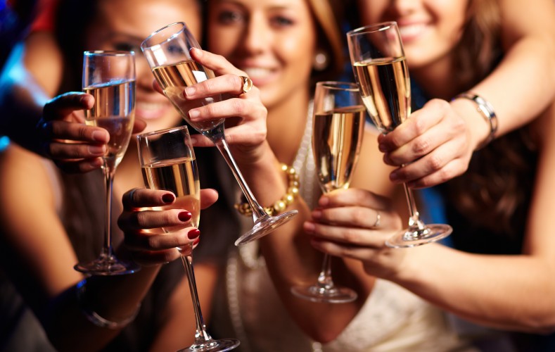Group of partying girls clinking flutes with sparkling wine