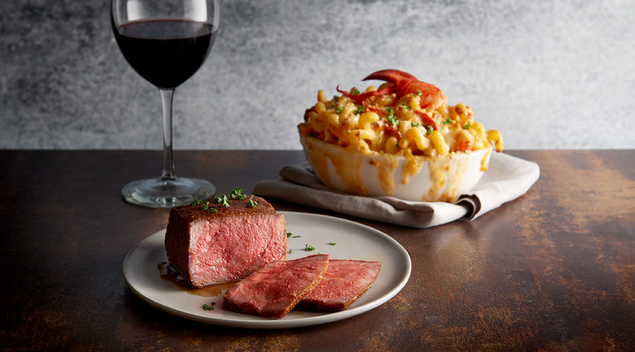 Morton’s steak, dish of lobster mac and cheese and a glass of red wine