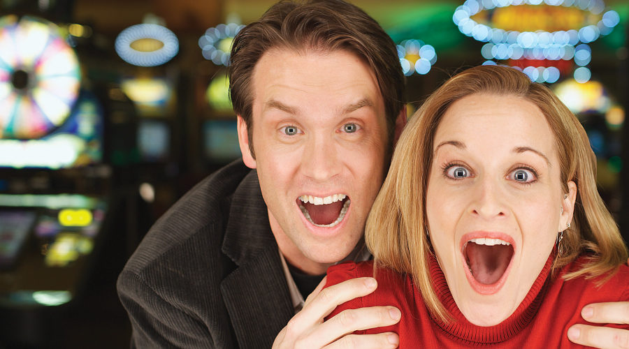 Couple at slot machine with excited expressions